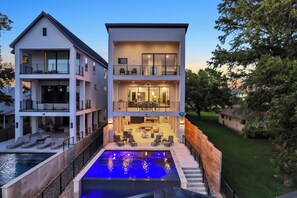 A modern two-story house with a swimming pool, outdoor seating, and a well-maintained lawn. - The High Life | Concierge Services (Kingsland)