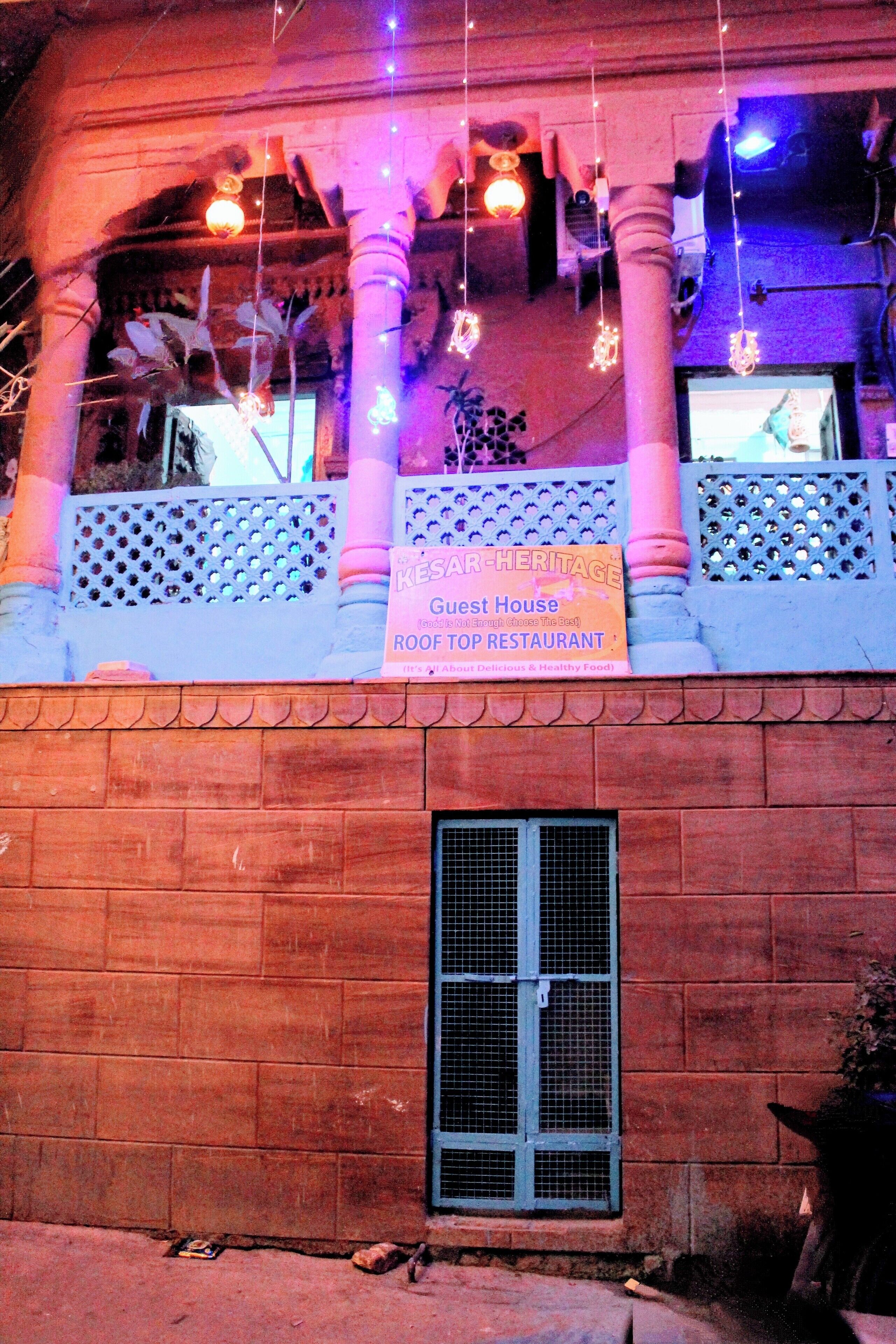 Un edificio con un letrero que indica que es una casa de huéspedes y restaurante en la azotea.