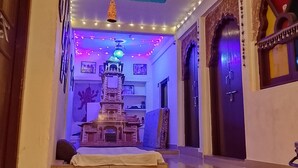 A corridor with a decorative structure, a ceiling with string lights, and a door with traditional design. - Kesar Heritage Guest House  (Jodhpur)