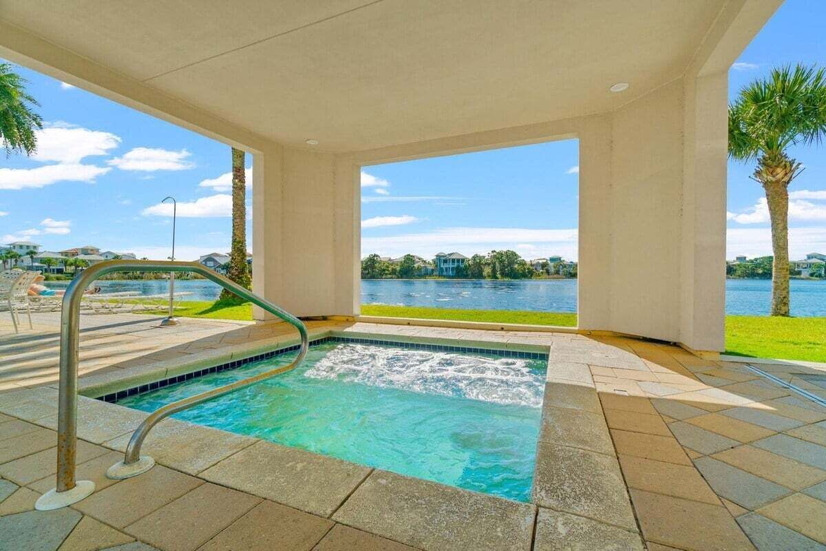A hot tub with a view of a lake and palm trees.