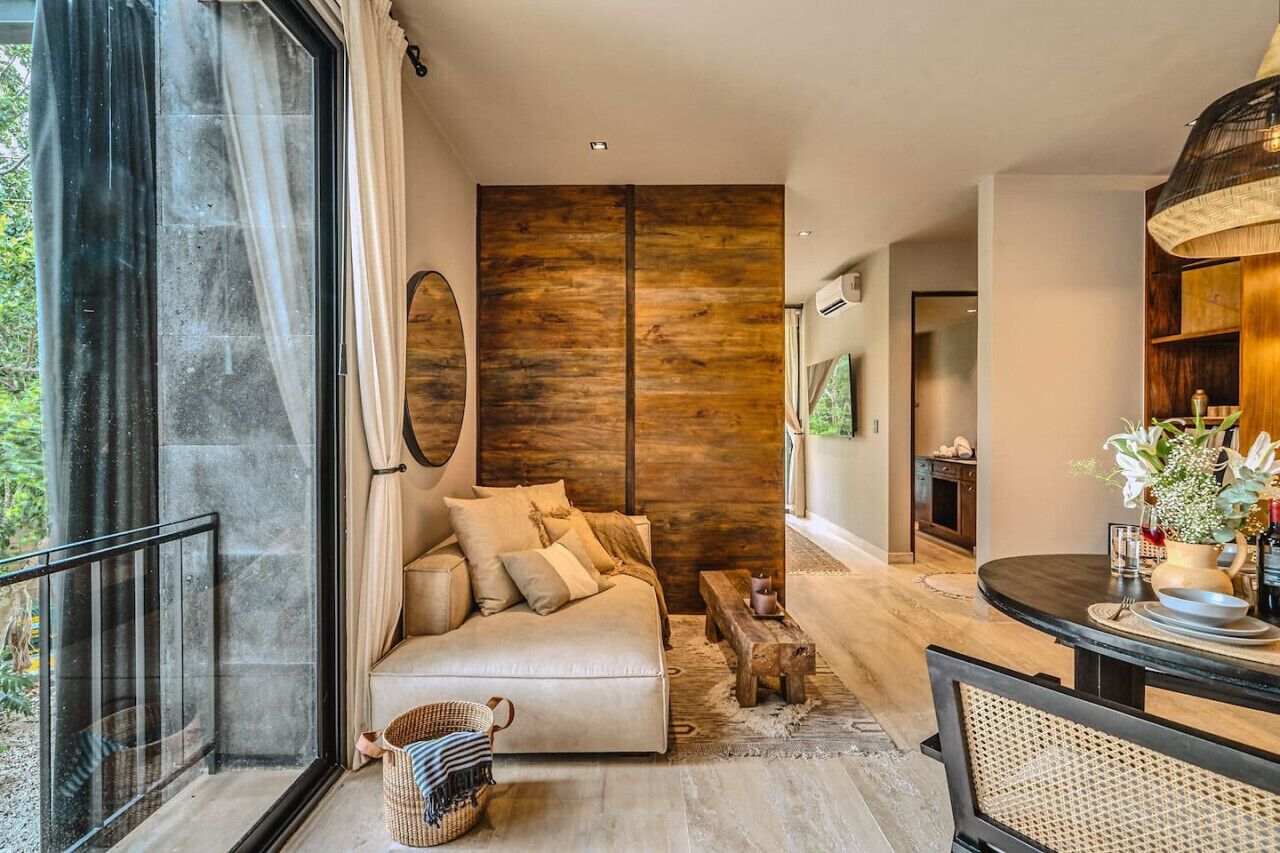 Un salon moderne avec un canapé, une table à manger et une grande fenêtre.