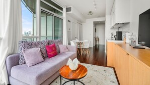 A modern living room with a sofa, a small round table, and a kitchen area with a counter and appliances. - GLOBALSTAY. Panoramic 1 Bedroom Condo in Downtown (Toronto/Canada)