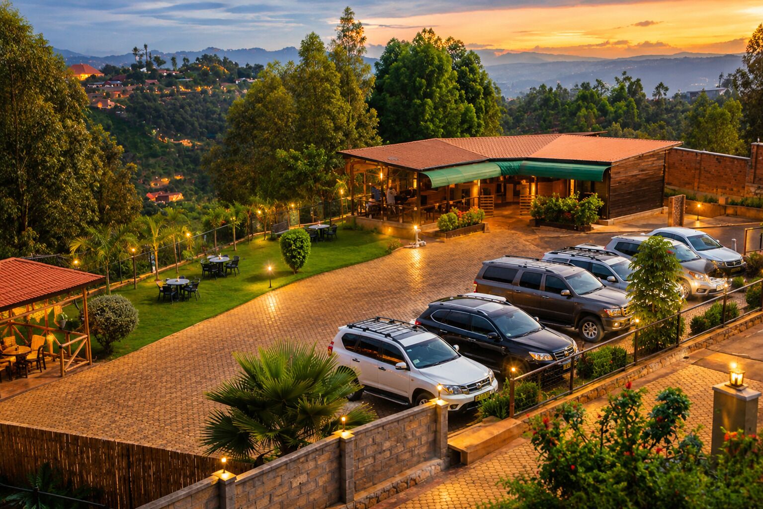 A hotel with a paved driveway, multiple parked cars, and a view of the surrounding landscape.