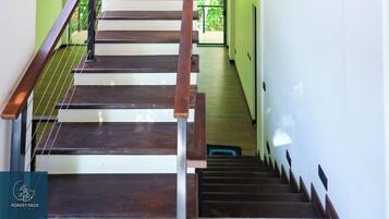 A staircase with wooden railings and a hanging light fixture.