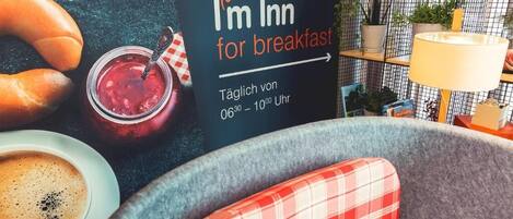 Un desayuno con un cartel que indica 'I'm Inn for breakfast', disponible diariamente de 06:30 a 10:00 Uhr.