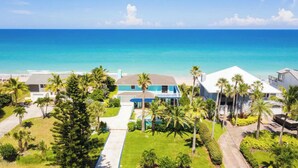 A coastal property with a large house, a pool, and a view of the ocean.