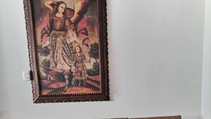 Ένας καφέ καναπές με ένα διακοσμητικό πλαίσιο ζωγραφιάς τοποθετημένο ακριβώς από πάνω.