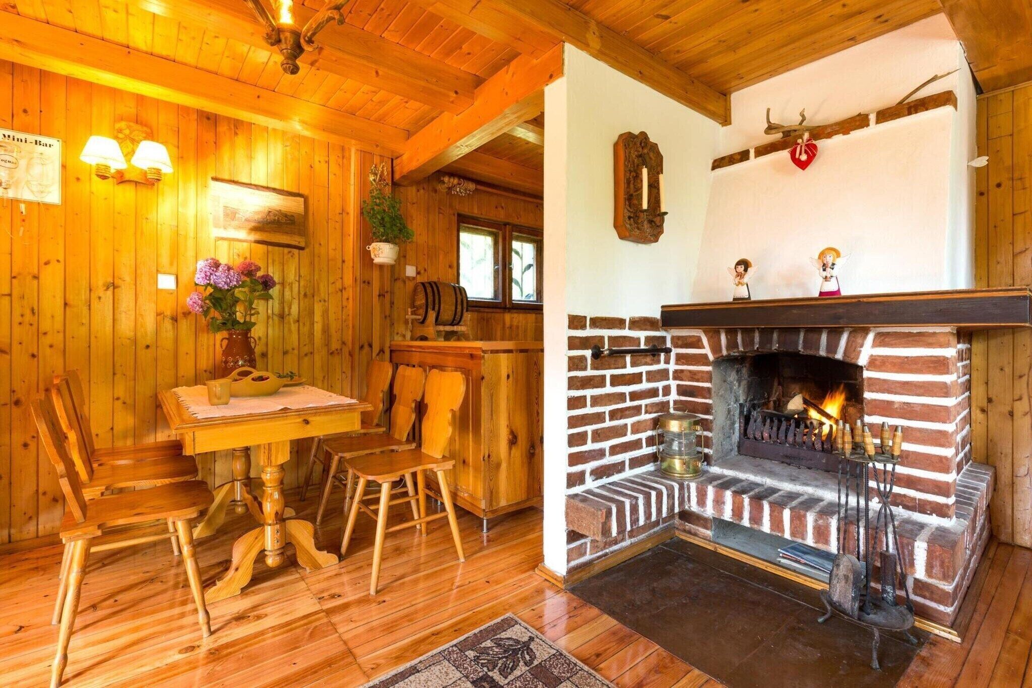 Un intérieur en bois avec une cheminée en briques, des meubles en bois et un coin repas.