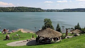 A lakeside view with a gazebo, a small wooden structure, and a boat dock.