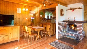 A wooden interior with a fireplace, wooden furniture, and a television.