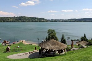 Une vue sur le lac, avec un belvédère, une petite construction en bois et un quai pour bateaux.