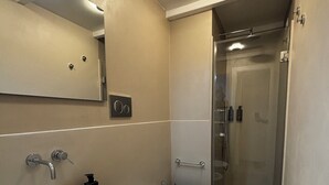 A modern bathroom with a large oval sink, a toilet, and a bidet. There is a mirror above the sink, and a shower area is visible in the background. - Suites Pantheon Rome - 3 (Roma)