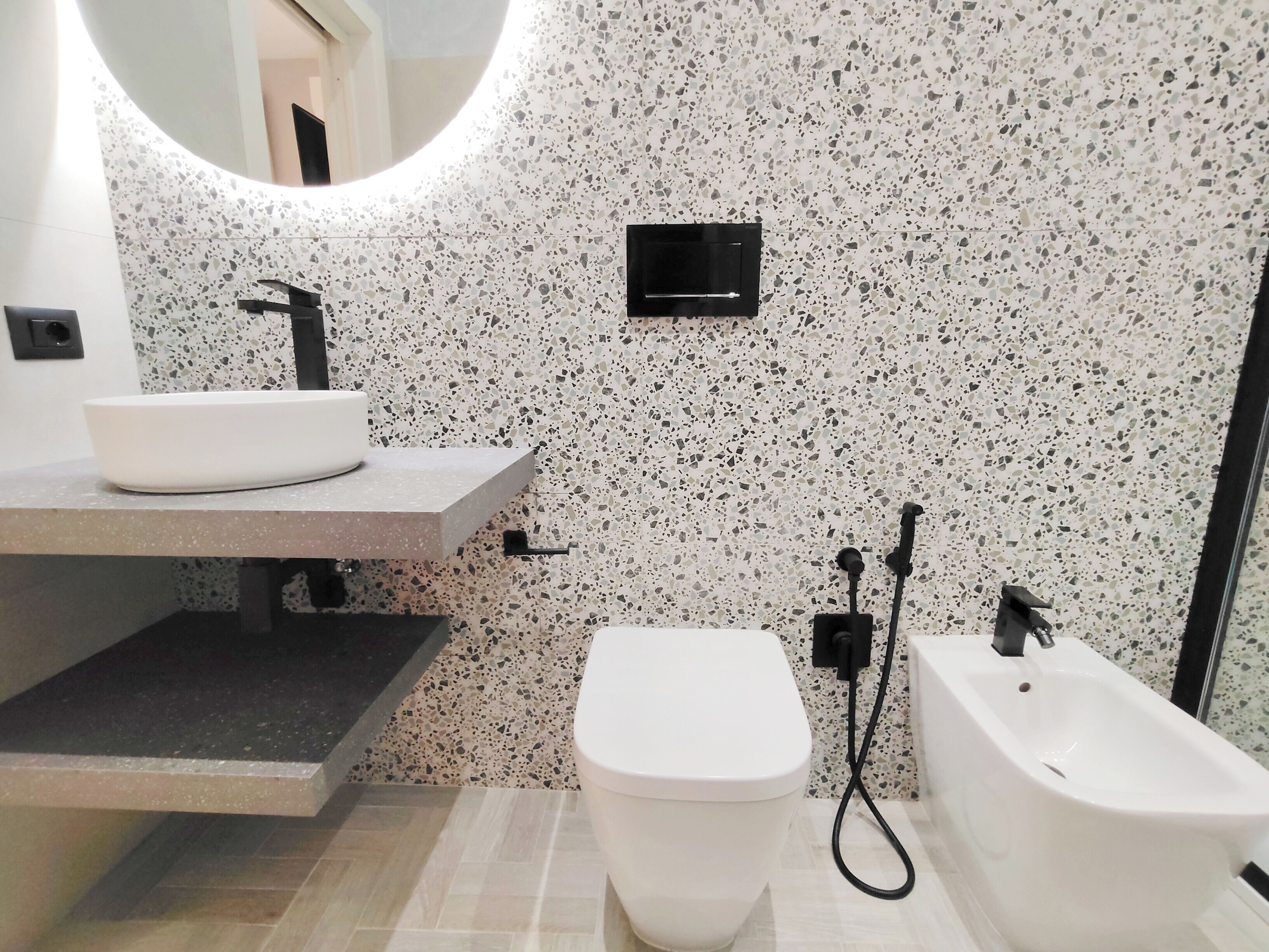 Een moderne badkamer met een wit wastafel, toilet en bad.