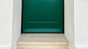 Une porte verte avec une poignée en laiton et une petite serrure.