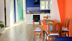 Une cuisine moderne avec un mur d’accent bleu, une table à manger en bois et des chaises.