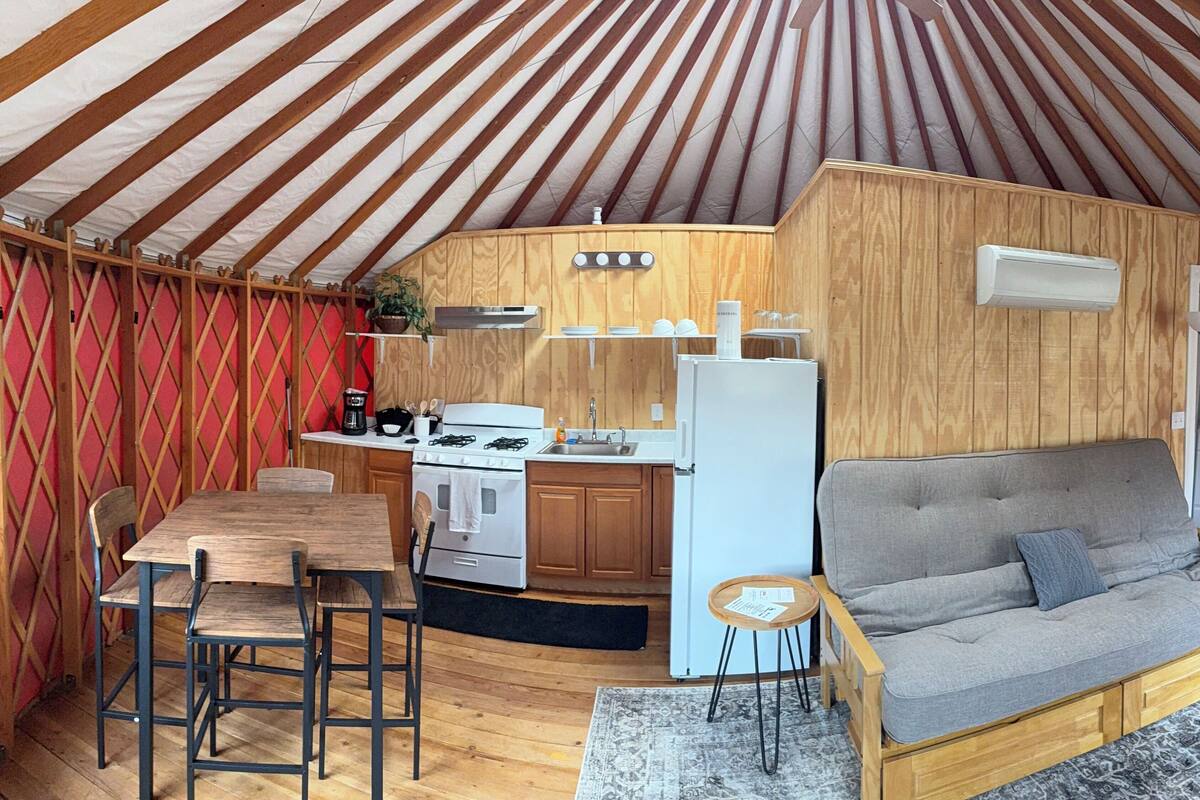 A cozy interior with a kitchen area, a dining table, and a sofa.