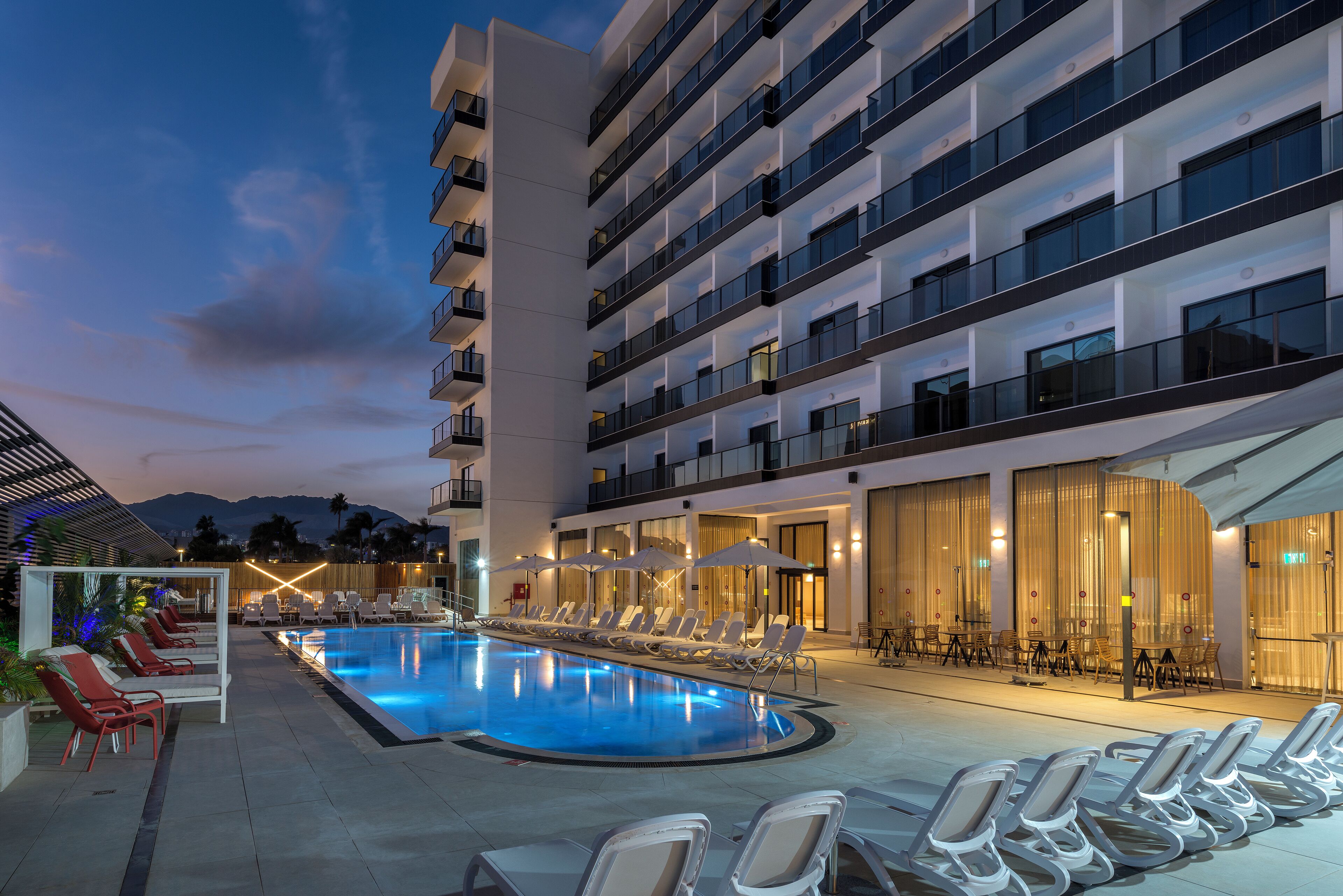 Una piscina al aire libre, sombrillas, tumbonas