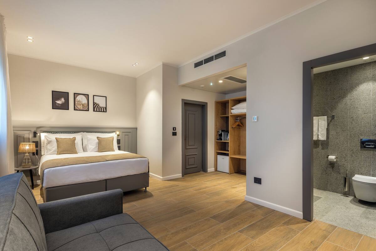 A modern bedroom with a large bed, a bedside table, and a wardrobe.
