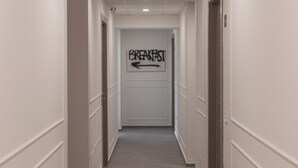 A hallway with a sign indicating the direction to the breakfast area. - Alexander House Hotel  (San Ferdinando)
