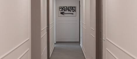A hallway with a sign indicating the direction to the breakfast area.