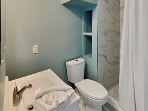 Un baño con una bañera blanca, un inodoro y una cortina de ducha.