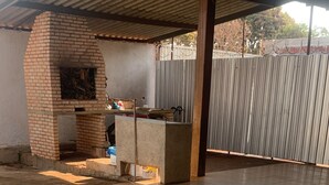 A covered patio area with a brick-built barbecue grill and a concrete counter. - Spacious 3-bedroom house in lovely Jardim Botanico with WiFi, AC (jardim botanico)