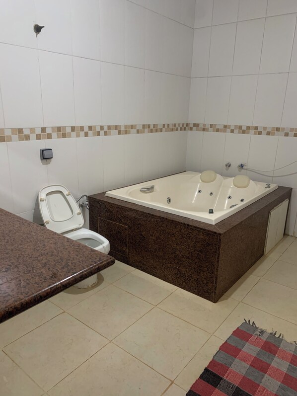 Un baño con inodoro, bañera y encimera de granito.