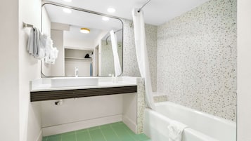 A bathroom with a white sink, mirror, and shower curtain.