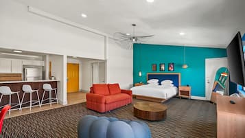 Een moderne hotelkamer met een bed, een bank, een salontafel en een bureau.