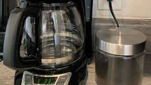 Une machine à café BLACK+DECKER dotée d’une horloge numérique, d’une verseuse en verre et d’une cafetière en acier inoxydable.