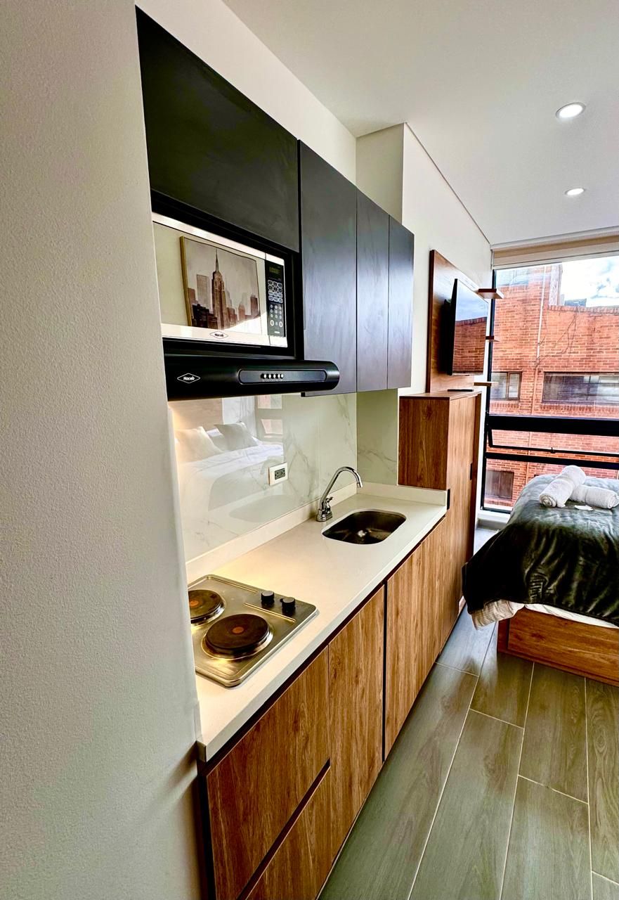 Una cocina moderna con estufa integrada, pileta y armarios de madera.