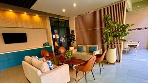 A modern living area with a sofa, chairs, a coffee table, and a TV. - 605-Estudio luminoso con balcón  (Bogotá)