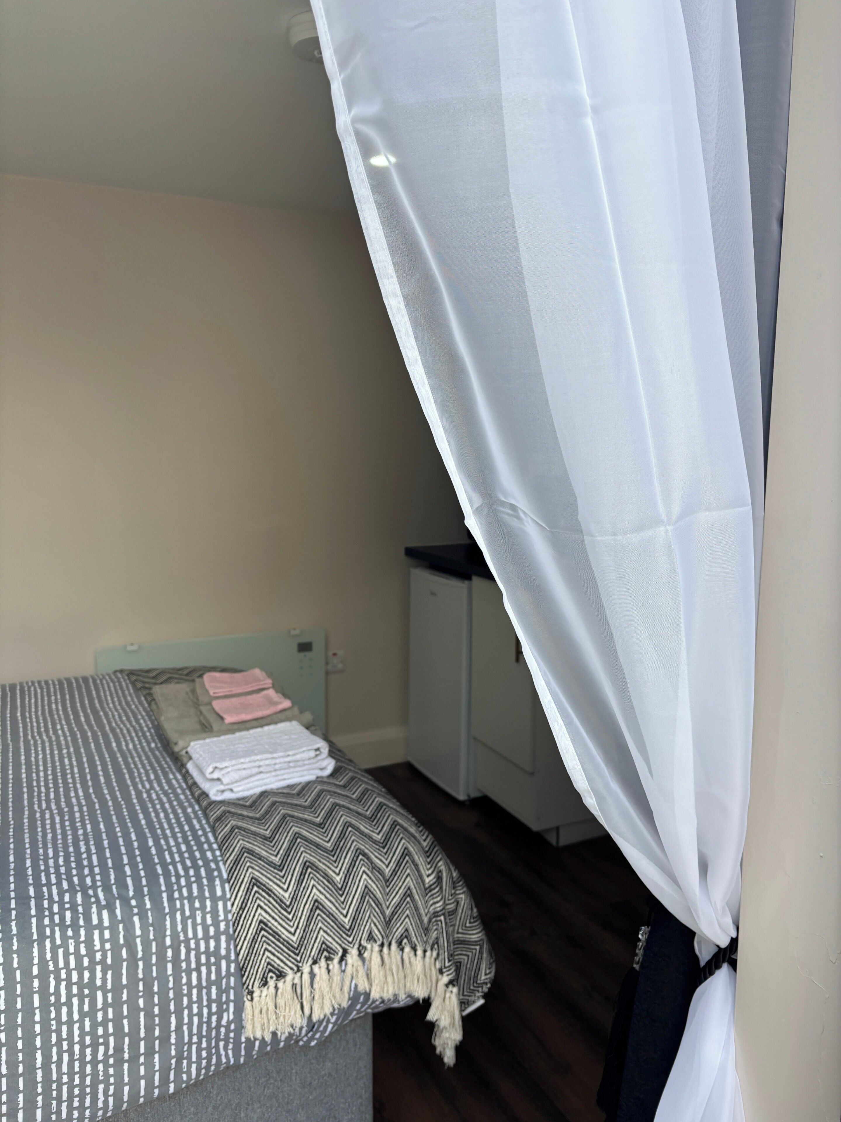 A bed with a patterned bedspread and a white canopy.