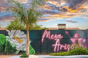 A wall with a mural of a flower and the words 'Mesa Arizona' in neon. - Heated Pool + Hot Tub | Backyard Resort | Games (Mesa)
