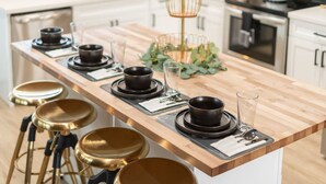 A kitchen with a wooden countertop, black bowls, and gold accents. - Heated Pool + Hot Tub | Backyard Resort | Games (Mesa)