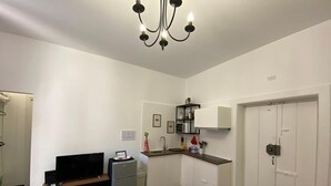 A compact living space with a dining area, kitchenette, and a television. - Apartment in the Borgo Antico, within walking distance of Largo Albicocca (Bari)