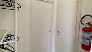 A narrow hallway with white walls, a closed door, and a fire extinguisher mounted on the wall. - Apartment in the Borgo Antico, within walking distance of Largo Albicocca (Bari)