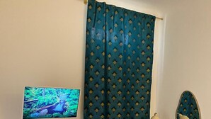 A room with a television, a desk, a chair, a bed, and a window with a curtain. - Apartment in the Borgo Antico, within walking distance of Largo Albicocca (Bari)