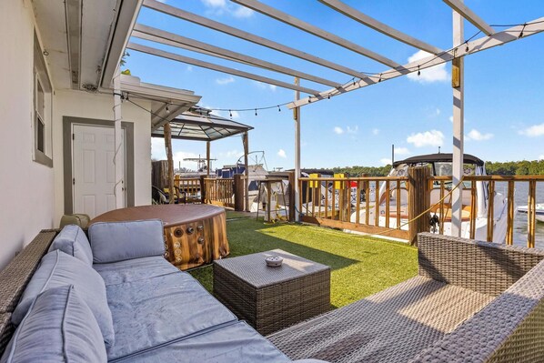 A covered outdoor area with a sofa, wicker furniture, and a small table.