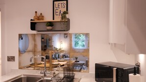 A modern kitchen with a double sink, a black toaster, and a decorative backsplash. - Stylish, Luxury Apartment Sleeps 4 - Southampton (Southampton)