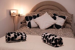 A neatly made bed with a patterned bedspread, two pillows with a cow print design, and a bedside lamp. - Stylish, Luxury Apartment Sleeps 4 - Southampton (Southampton)
