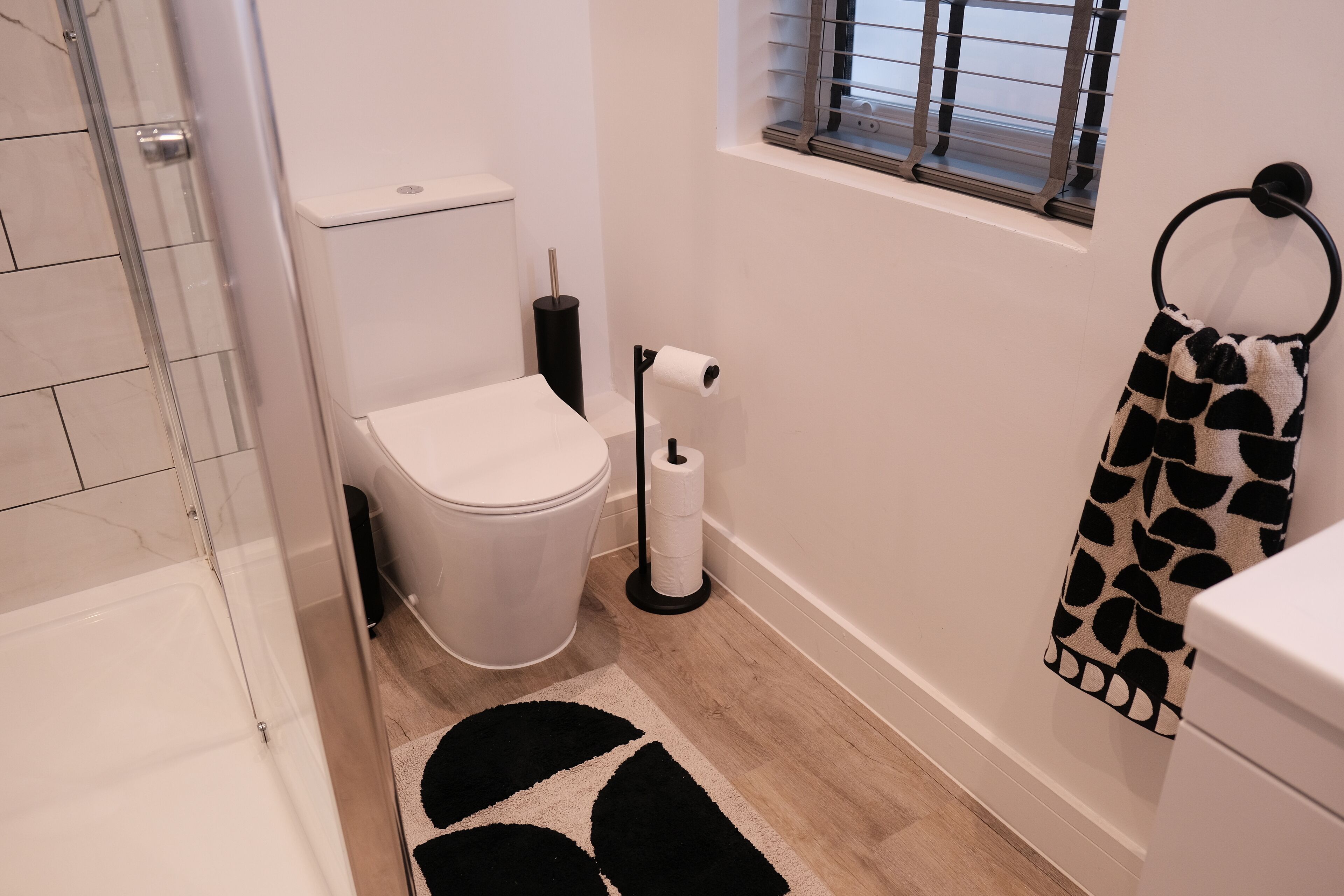 A bathroom with a toilet, bidet, and a towel rack.