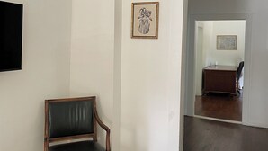 A room with a wooden chair, a framed picture on the wall, and a rug on the floor. - 2Bed 1Bath 1930s KC Home off I-35 ~ Walking Distance to Coffee & Breakfast (Kansas City)