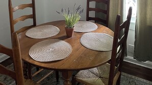 A round wooden dining table with four chairs, a potted plant, and a framed picture on the wall. - 2Bed 1Bath 1930s KC Home off I-35 ~ Walking Distance to Coffee & Breakfast (Kansas City)