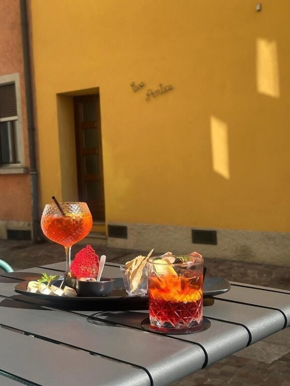 Egy asztal, rajta két ital, egy desszert és egy kis tányér, melyen étel van.