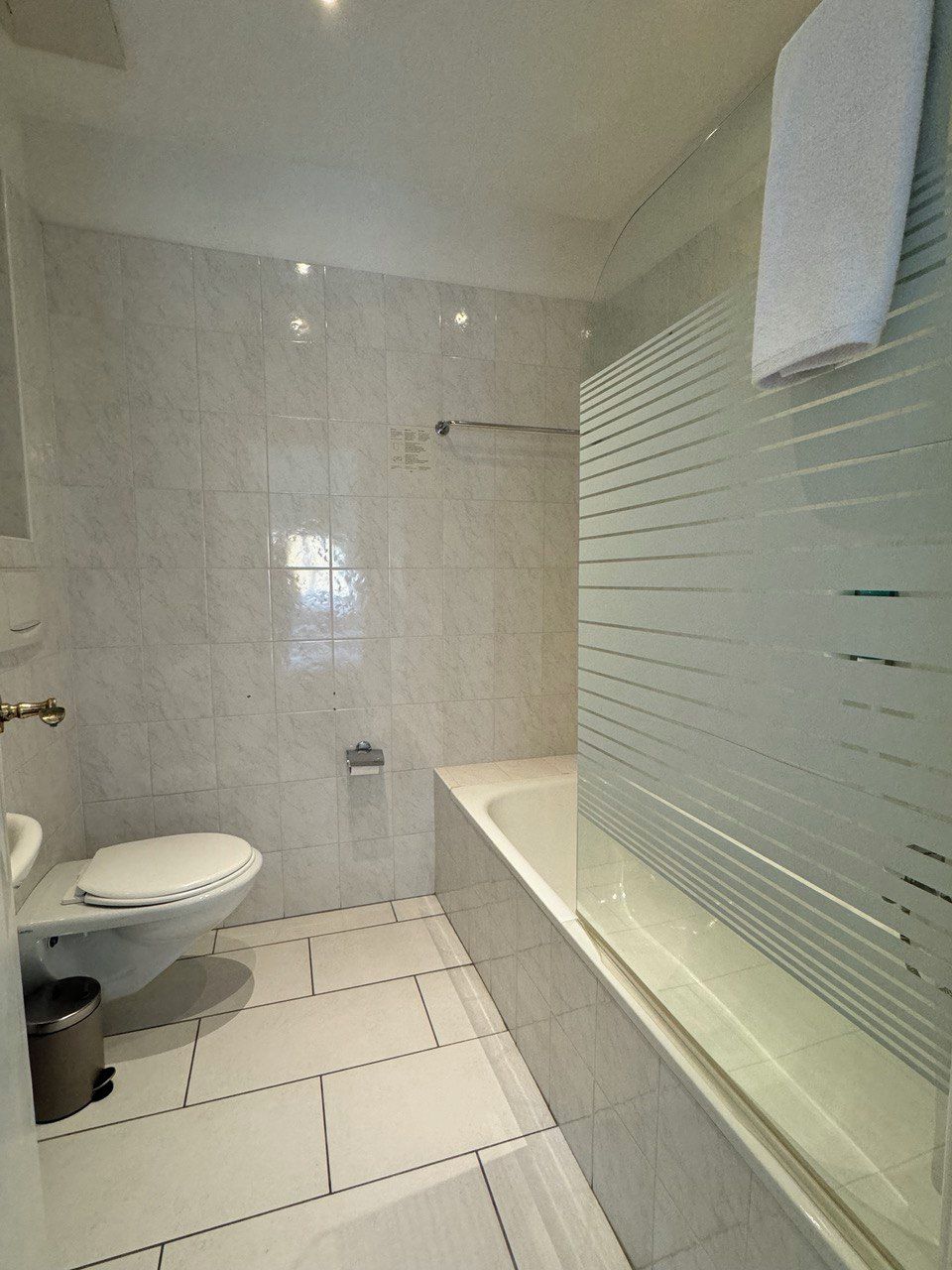 Ein modernes Badezimmer mit Toilette, Waschbecken und Badewanne.