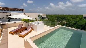 A rooftop pool area with lounge chairs and a pergola. - oasis yaaxlum (Tulum)