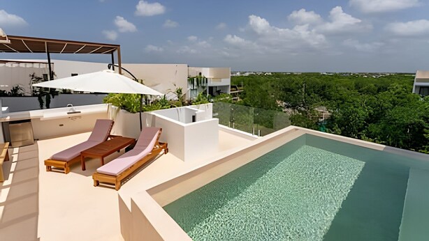 A rooftop pool area with lounge chairs and a pergola. - oasis yaaxlum (Tulum)