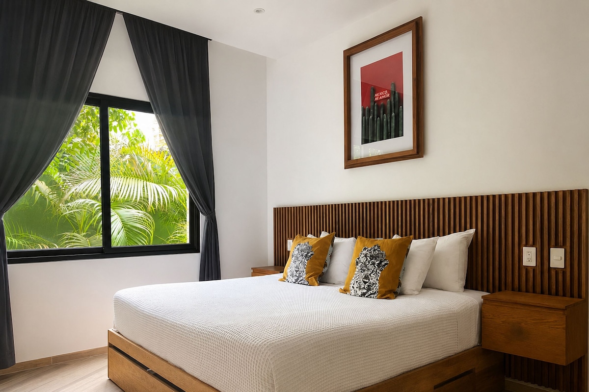 A modern bedroom with a large bed, wooden headboard, and a window with curtains.