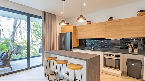 A modern kitchen with wooden cabinets, a central island with stools, a black backsplash, and a large window offering a view of greenery. - oasis yaaxlum (Tulum)